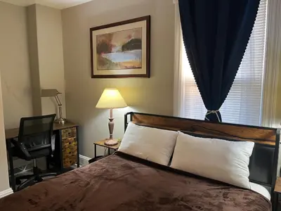 a bedroom with a bed and a chair and a window at Little France Alsace in Phillipsburg