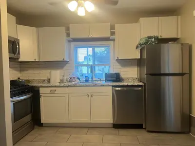 a kitchen with white cabinets and a stainless steel refrigerator at Little France Alsace in Phillipsburg