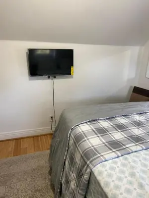 a bedroom with a bed and a flat screen tv on the wall at Cjay home 3 in Jersey City