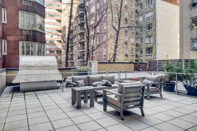 a patio with benches and a fountain and buildings at Blueground Murray Hill fitness center nr MetLife NYC-1929 in New York