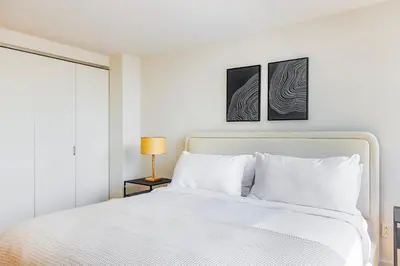 a white bedroom with a white bed and a window at Blueground Tribeca pool nr City Hall NYC-1930 in New York