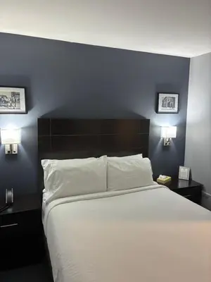 a bedroom with a large white bed with two night stands at Mainstay Inn in Phoenixville