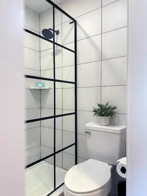 a bathroom with a toilet and a glass wall at Mainstay Inn in Phoenixville