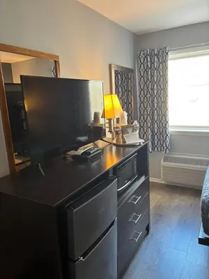a bedroom with a black dresser with a flat screen tv at Mainstay Inn in Phoenixville