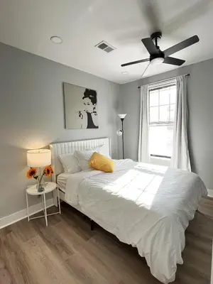 a bedroom with a white bed with a ceiling fan at New Spacious 2 bedroom in Central Philly in Philadelphia