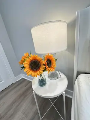 a table with a vase of sunflowers on it at New Spacious 2 bedroom in Central Philly in Philadelphia