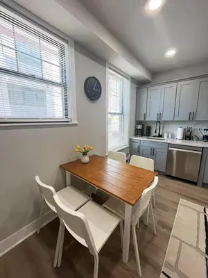 a kitchen with a wooden table and white chairs at New Spacious 2 bedroom in Central Philly in Philadelphia