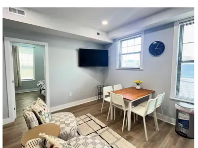 a living room with a table and chairs and a tv at New Spacious 2 bedroom in Central Philly in Philadelphia