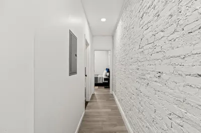 a hallway with white walls and a brick wall at The Soft Loft in Philadelphia