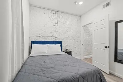 a bedroom with a bed and a white brick wall at The Soft Loft in Philadelphia