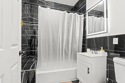 a black and white bathroom with a shower and a sink at The Soft Loft in Philadelphia