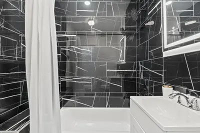 a black and white bathroom with a shower and a sink at The Soft Loft in Philadelphia