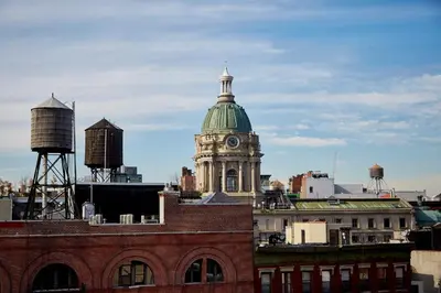 a building with a clock tower with a green roof at NobleDEN Hotel in New York