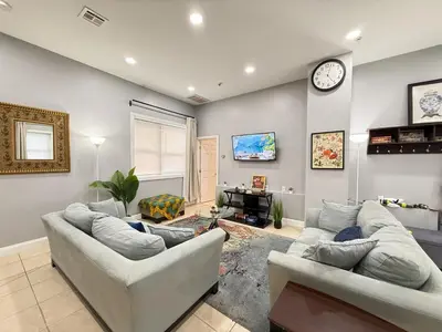 a living room with two couches and a clock on the wall at Huge apartment near NYC, Parking in North Bergen