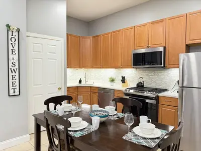 a kitchen with a table with chairs and a refrigerator at Huge apartment near NYC, Parking in North Bergen