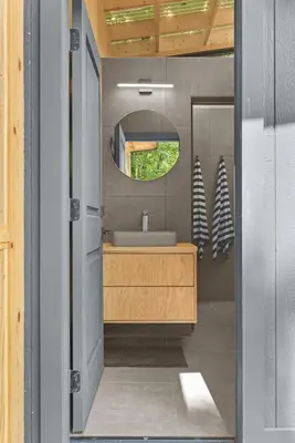 a bathroom with a sink and a mirror at Sunlit Airstream in Trees with Expansive Deck Nature Views in De Lancey