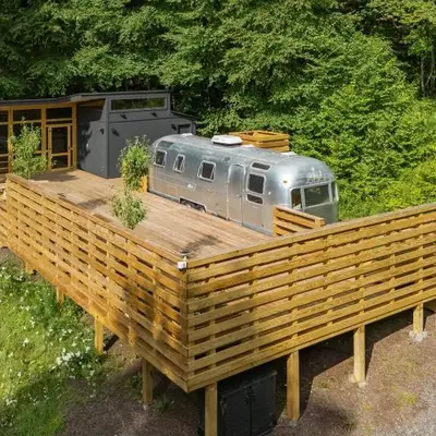 Sunlit Airstream in Trees with Expansive Deck Nature Views