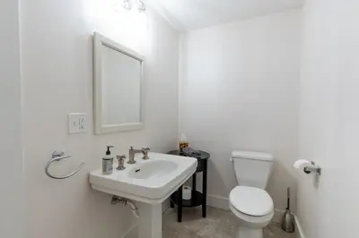 a white bathroom with a sink and a toilet at Spectacular Buckleberry View EV Recharge Hot Tub Fireplace Jacuzzi in Spring Mills