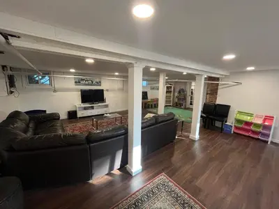 a living room with a couch and a table at Grand Bergen Home Near NYC-Shops in Maywood