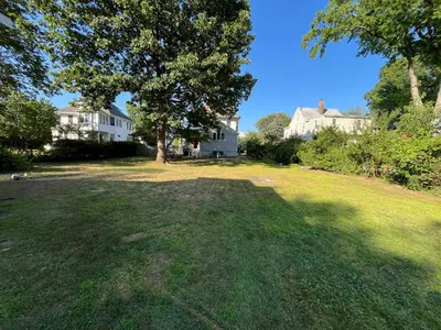 a large yard with a large tree and houses at Grand Bergen Home Near NYC-Shops in Maywood