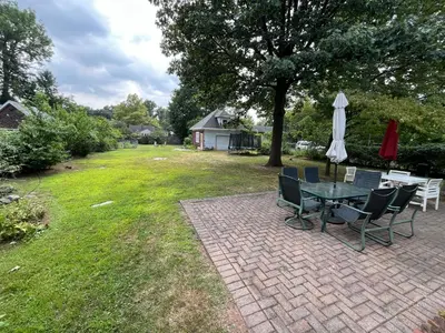 a patio with a table and chairs and an umbrella at Grand Bergen Home Near NYC-Shops in Maywood