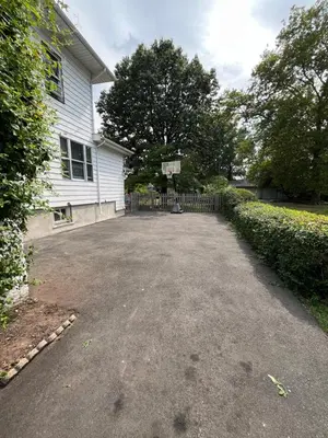 a driveway in front of a white house at Grand Bergen Home Near NYC-Shops in Maywood