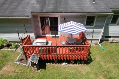 a deck with a table and an umbrella at Catskills Getaway 3BR Retreat with Media Room, Near Casino, Bethel Woods and More in Glen Wild