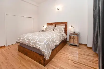 a bedroom with a large bed and a wooden floor at Luxury Apartments Next to Times Square in New York