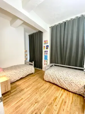two beds in a room with wooden floors at Luxury Apartments Next to Times Square in New York