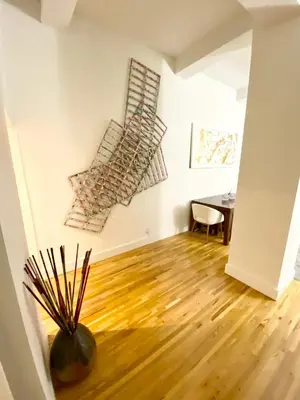 a room with a table and a vase on a wooden floor at Luxury Apartments Next to Times Square in New York