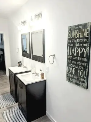 a bathroom with two sinks and a happy anniversary shower curtain at Cozy Guesthouse in Catasauqua