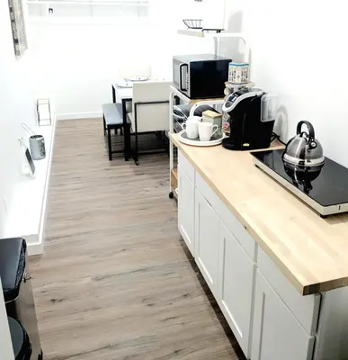 a kitchen with white cabinets and a wooden counter top at Cozy Guesthouse in Catasauqua