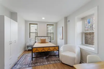 a bedroom with a bed and a chair in it at Welcome to The Lux Collective a Spacious 5-Bedroom House close to Stadiums, Universities, Center City & more! in Philadelphia