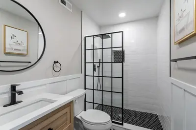 a bathroom with a toilet and a sink and a mirror at Welcome to The Lux Collective a Spacious 5-Bedroom House close to Stadiums, Universities, Center City & more! in Philadelphia