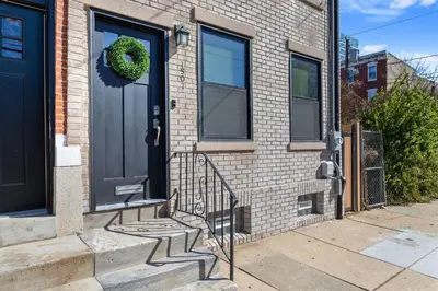 a front door of a brick house with a wreath on it at Welcome to The Lux Collective a Spacious 5-Bedroom House close to Stadiums, Universities, Center City & more! in Philadelphia