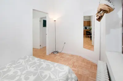 a white bedroom with a bed and a mirror at Mid Town East Street Apartments Next to Times Square in New York