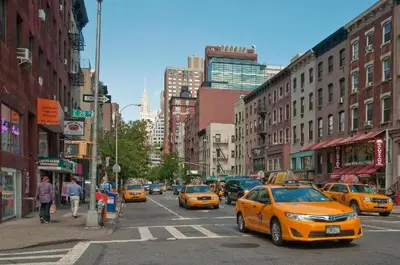 a busy city street with yellow cabs in traffic at Mid Town East Street Apartments Next to Times Square in New York