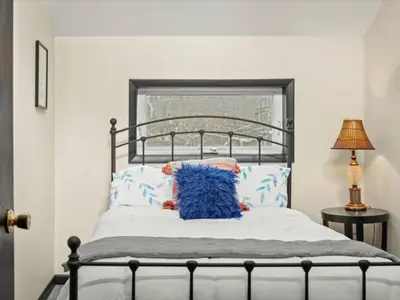 a bed with a blue pillow on top of it at Memorabile Getaway Fire-Pit and Entrainment Area in Long Pond