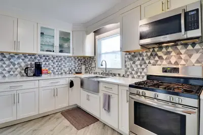 a kitchen with white cabinets and stainless steel appliances at 5 Mi to Dtwn Newark Hillside Vacation Rental in Hillside
