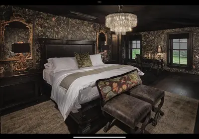 a bedroom with a bed and a chair and a chandelier at Carversville Inn in New Hope