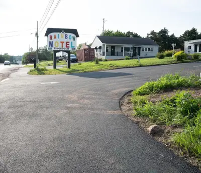an empty street with a sign for a motel at Rainbow Motel in Douglassville