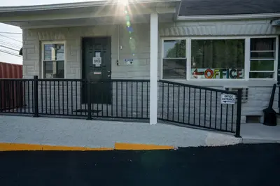 a building with a black fence in front of it at Rainbow Motel in Douglassville