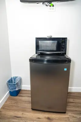 a microwave sitting on top of a refrigerator at Rainbow Motel in Douglassville