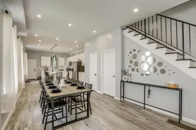 a kitchen and dining room with a table and a staircase at Group Getaway with Games and Patio in Philadelphia! in Philadelphia