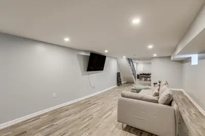 a living room with a couch and a flat screen tv at Group Getaway with Games and Patio in Philadelphia! in Philadelphia