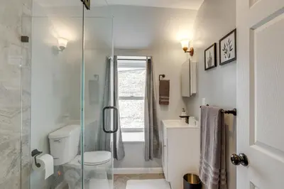 a bathroom with a toilet and a glass shower at Group Getaway with Games and Patio in Philadelphia! in Philadelphia