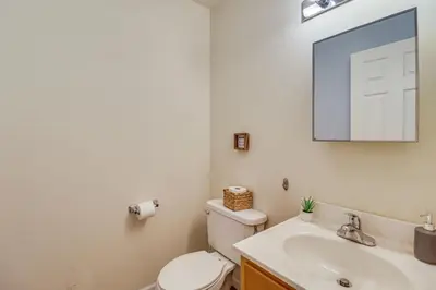 a bathroom with a toilet and a sink and a mirror at Family Retreat with 2 Game Rooms and Deck in Long Pond in Long Pond