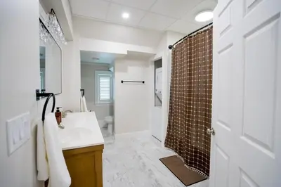a bathroom with a shower and a white sink at Cozy Corner Near UPMC & Downtown in Williamsport