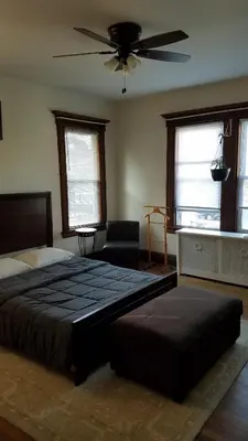 a bedroom with a large bed and a ceiling fan at Weehawken on Hudson in Union City