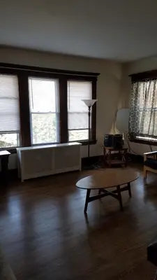 a living room with a table and some windows at Weehawken on Hudson in Union City